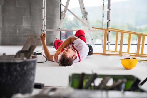 A man who fell off of ladder at lying on the floor in pain.