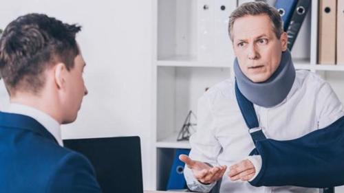 A man meeting with a lawyer after suffering an injury during an accident at work.