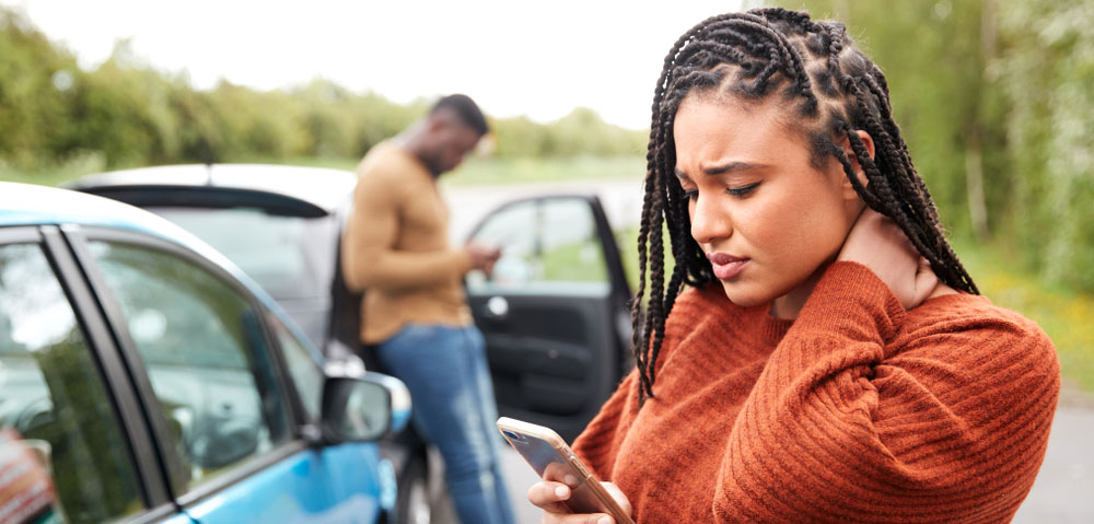 A woman who was just in a car crash, holding her neck in pain.